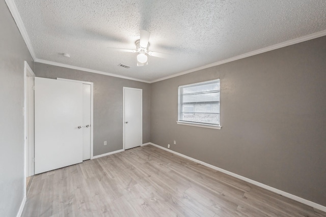 unfurnished bedroom with ceiling fan, ornamental molding, light hardwood / wood-style floors, and a textured ceiling