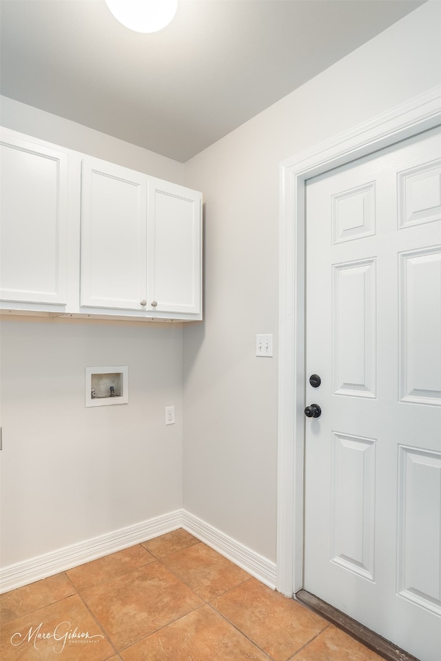 clothes washing area with cabinets, washer hookup, and light tile patterned floors