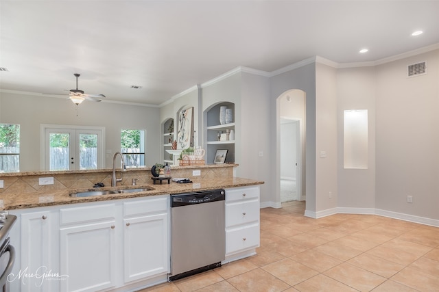 kitchen with sink, appliances with stainless steel finishes, light stone countertops, white cabinets, and french doors