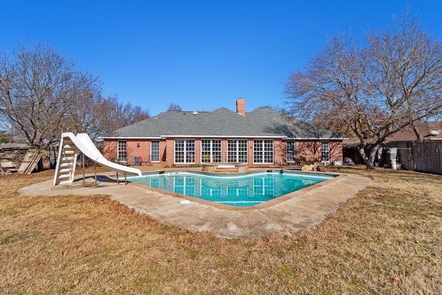 view of swimming pool with a yard, a water slide, and a patio area