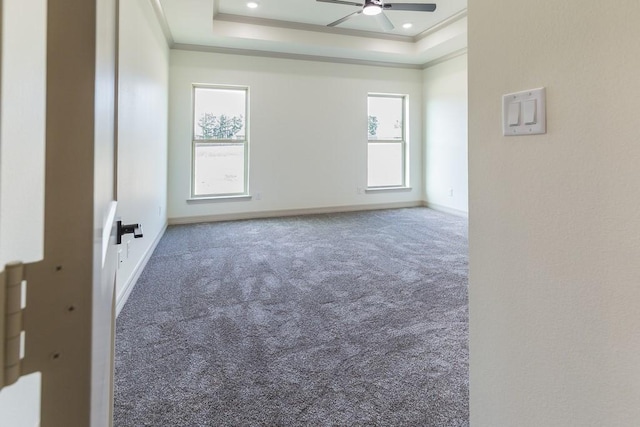 unfurnished room featuring a tray ceiling, crown molding, carpet floors, and ceiling fan