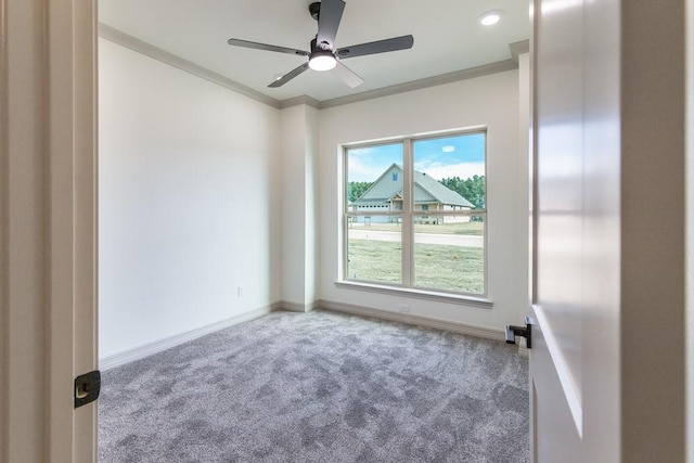 carpeted spare room with crown molding and ceiling fan