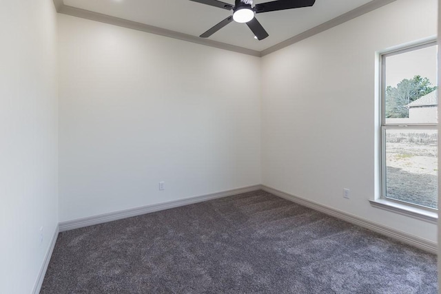 spare room with ceiling fan, crown molding, a healthy amount of sunlight, and dark colored carpet