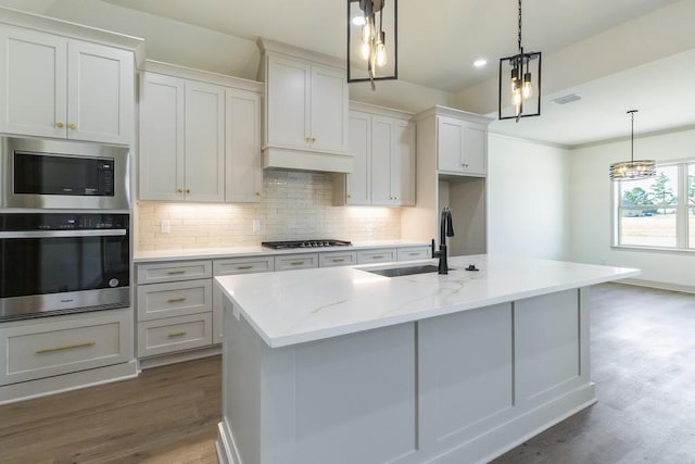 kitchen featuring white cabinetry, hanging light fixtures, an island with sink, and appliances with stainless steel finishes