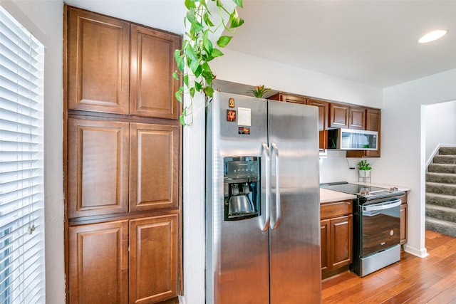 kitchen with stainless steel appliances and light hardwood / wood-style floors