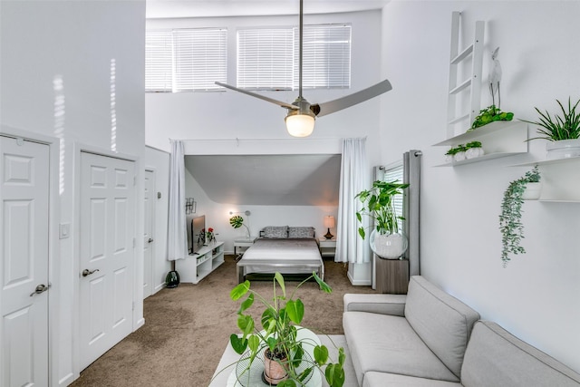 carpeted bedroom featuring multiple windows and a high ceiling