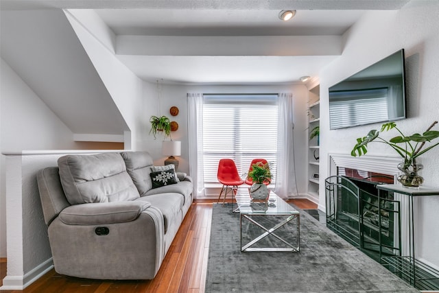 living room featuring dark wood-type flooring and built in shelves