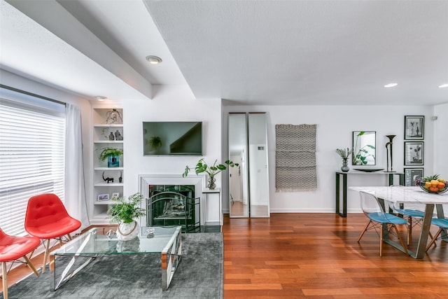 living room with dark hardwood / wood-style floors, a textured ceiling, and built in shelves