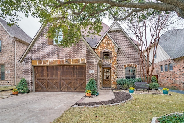 tudor home with a garage and a front yard