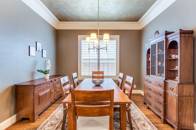 dining space featuring ornamental molding, a chandelier, and light wood-type flooring