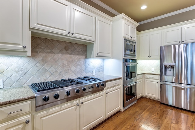 kitchen with white cabinetry, crown molding, light hardwood / wood-style flooring, and stainless steel appliances