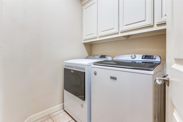 laundry room featuring cabinets, washer and dryer, and light tile patterned floors