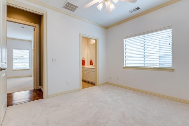 unfurnished bedroom featuring connected bathroom, ornamental molding, and light colored carpet