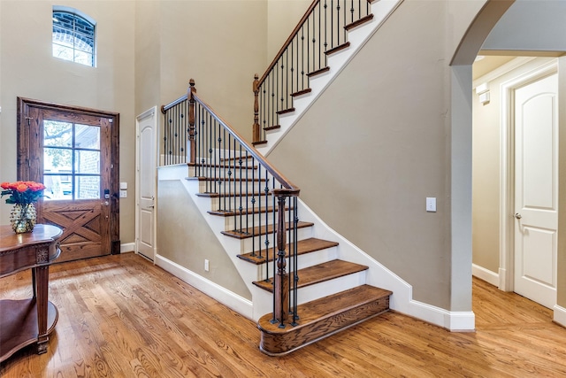 entryway featuring a towering ceiling and light hardwood / wood-style floors