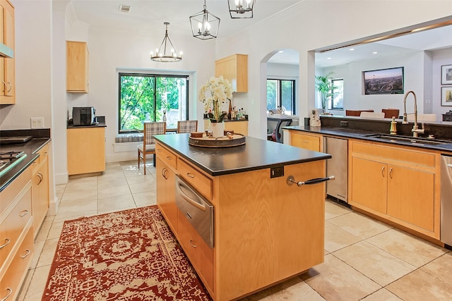 kitchen with a kitchen island, sink, a chandelier, hanging light fixtures, and crown molding