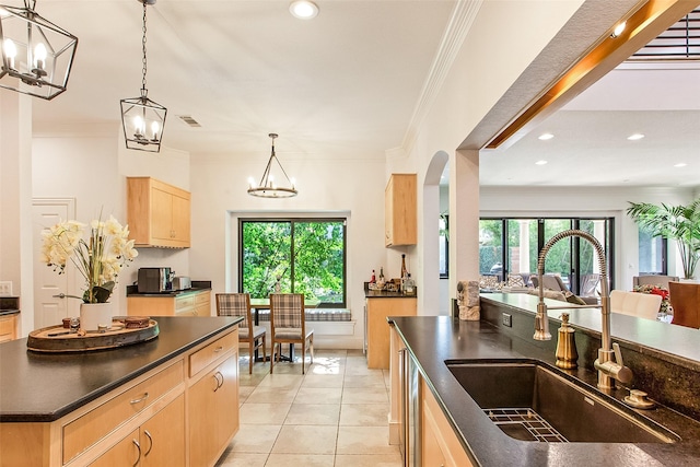 kitchen featuring sink, an inviting chandelier, crown molding, light brown cabinets, and pendant lighting