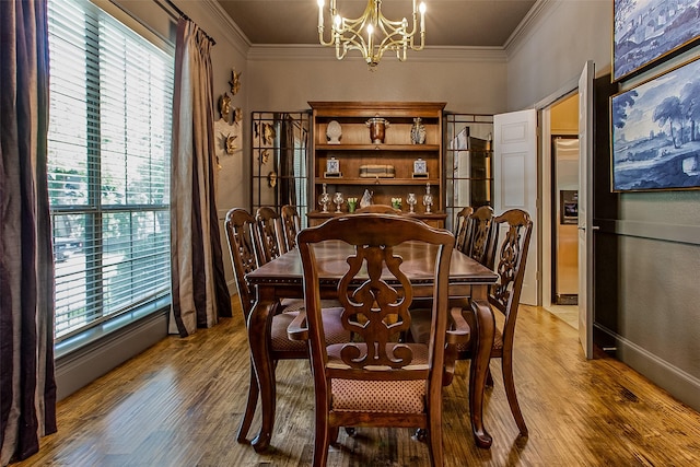 dining room with a notable chandelier, hardwood / wood-style flooring, and ornamental molding