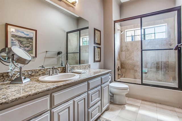 full bathroom with vanity, tile patterned flooring, shower / bath combination with glass door, and toilet