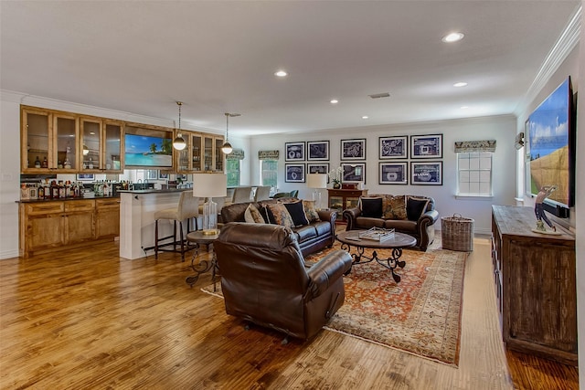 living room with light hardwood / wood-style flooring and ornamental molding