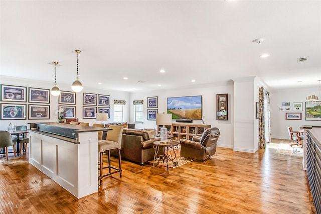 living room with crown molding and light wood-type flooring