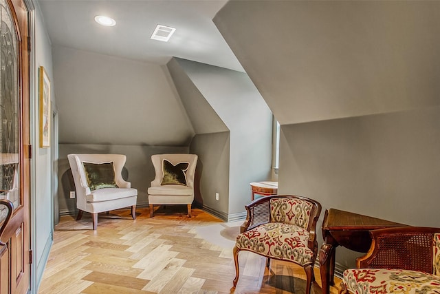 sitting room with vaulted ceiling and light parquet flooring