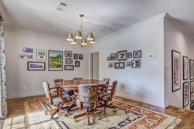 dining space featuring a notable chandelier, wood-type flooring, and ornamental molding