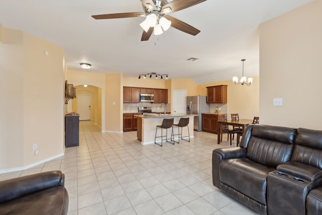 living room featuring sink, ceiling fan with notable chandelier, track lighting, and light tile patterned flooring