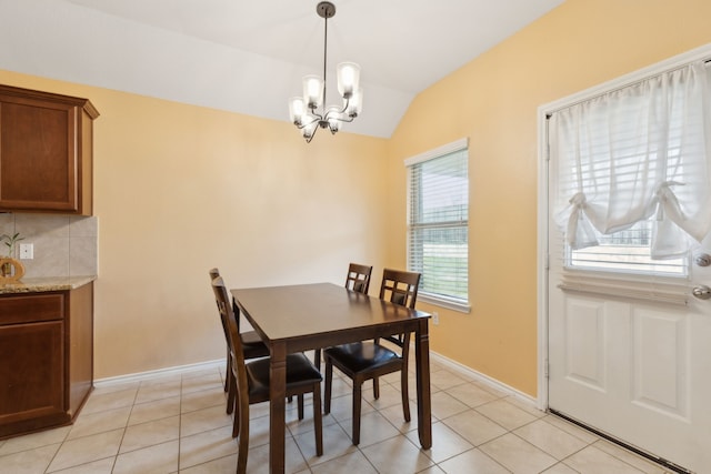 tiled dining area featuring vaulted ceiling and a chandelier