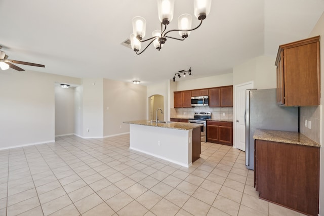 kitchen with decorative backsplash, appliances with stainless steel finishes, open floor plan, a sink, and ceiling fan with notable chandelier