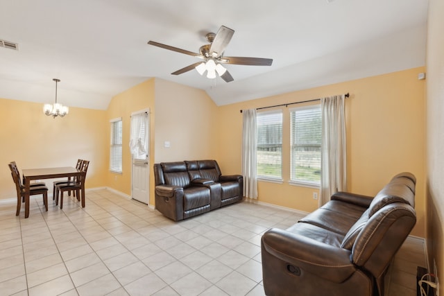 tiled living room featuring vaulted ceiling and ceiling fan with notable chandelier