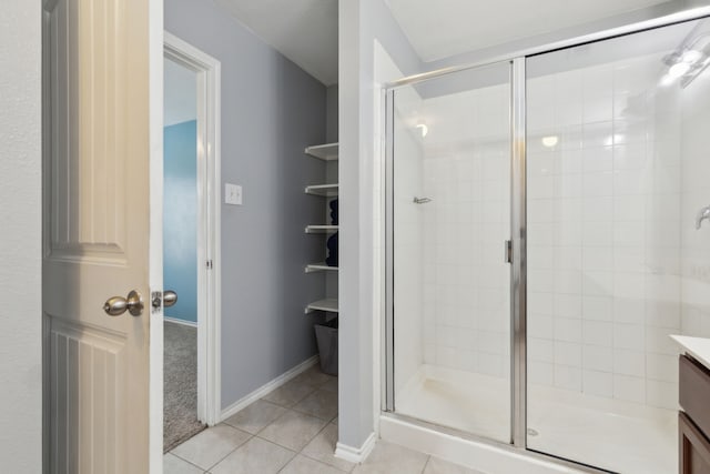 bathroom with tile patterned flooring, vanity, and a shower with door