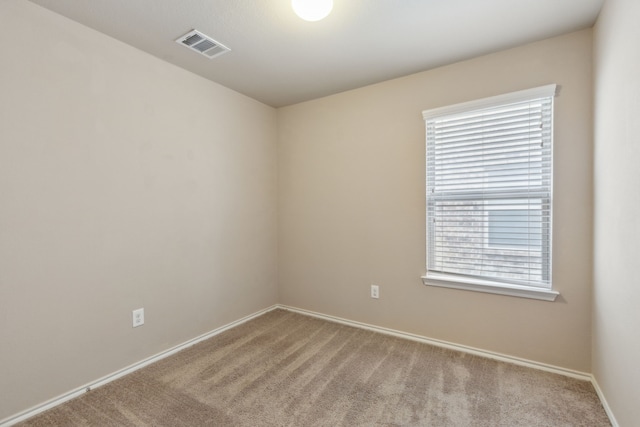 unfurnished room with light colored carpet and plenty of natural light