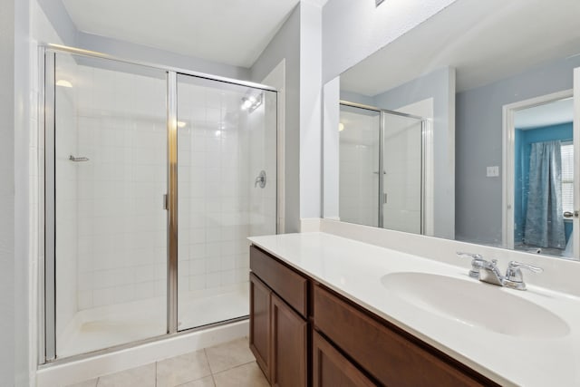 bathroom featuring vanity, a shower with shower door, and tile patterned floors