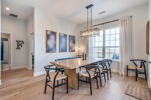 dining space with light wood-style floors, baseboards, and visible vents