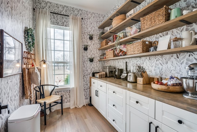 bar featuring baseboards, light wood-style floors, and wallpapered walls