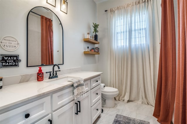 bathroom featuring toilet, marble finish floor, and vanity