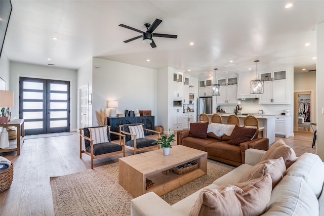 living area featuring recessed lighting, a ceiling fan, baseboards, french doors, and light wood-type flooring