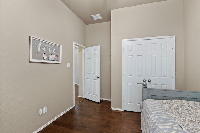 bedroom with dark hardwood / wood-style flooring and a closet