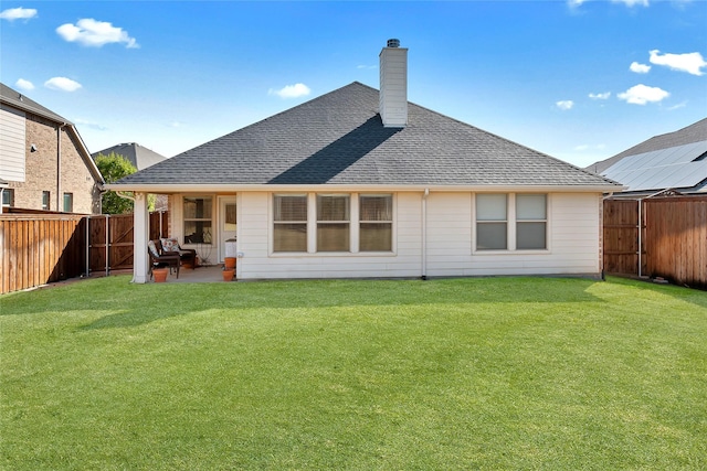 rear view of house with a lawn and a patio