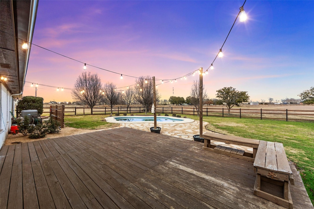 deck at dusk with a fenced in pool and a lawn