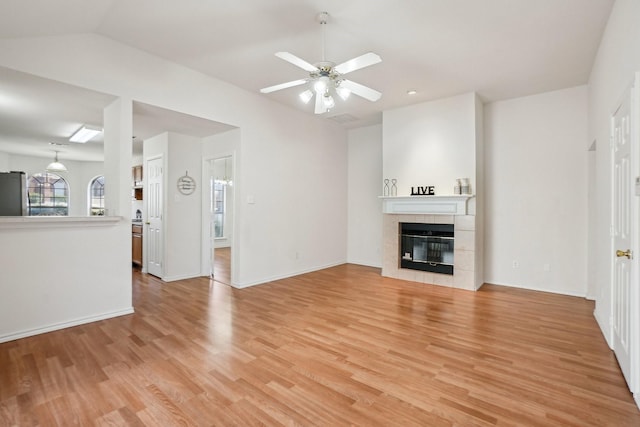 unfurnished living room featuring a fireplace, light hardwood / wood-style floors, and ceiling fan