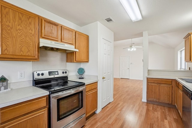 kitchen featuring vaulted ceiling, appliances with stainless steel finishes, sink, ceiling fan, and light hardwood / wood-style floors