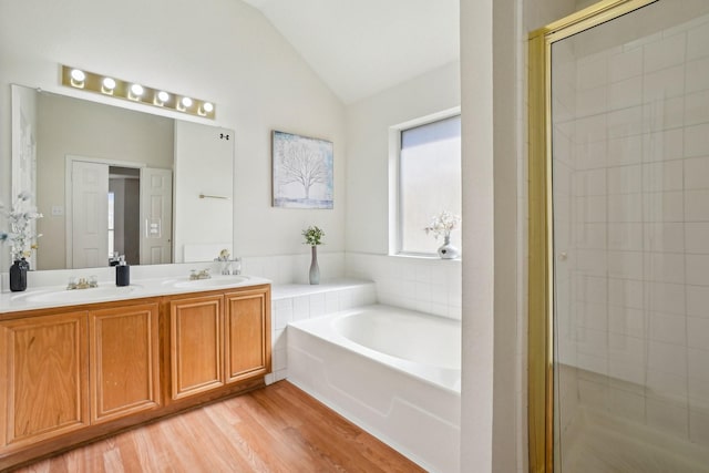 bathroom with vanity, hardwood / wood-style floors, vaulted ceiling, and plus walk in shower