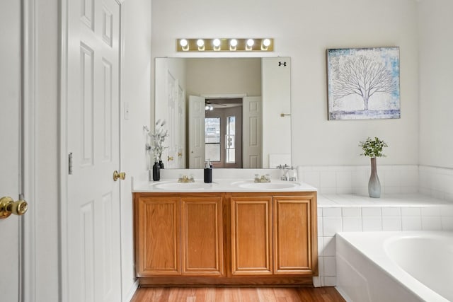 bathroom featuring vanity, a bath, and hardwood / wood-style floors