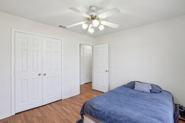 bedroom featuring hardwood / wood-style flooring, ceiling fan, and a closet