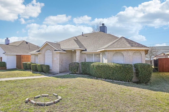 ranch-style home with a garage and a front lawn