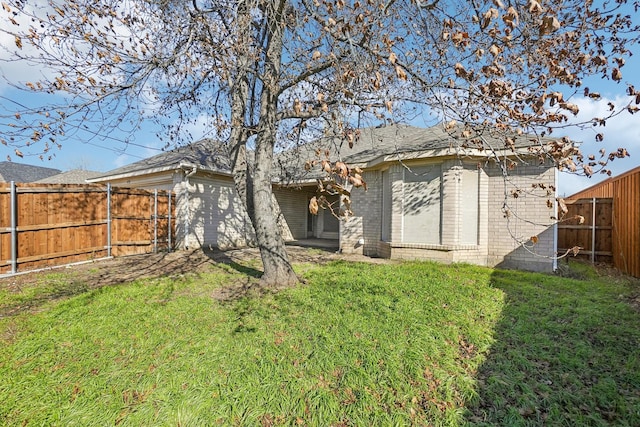 back of house with a lawn