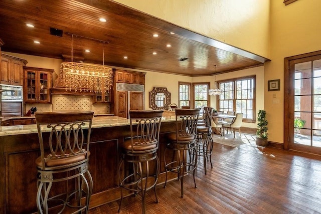 bar with wood ceiling, decorative light fixtures, and built in appliances