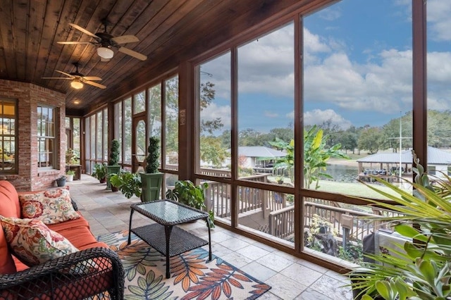 sunroom / solarium with a water view and wooden ceiling