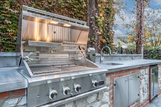 exterior space with a grill, sink, and beverage cooler